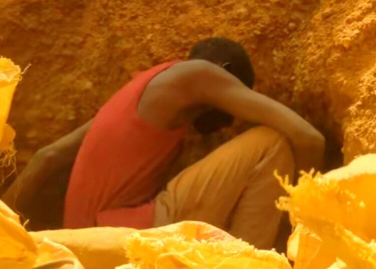 An artisanal gold miner digging inside a pit in Sudan, where air strikes killed gold miners