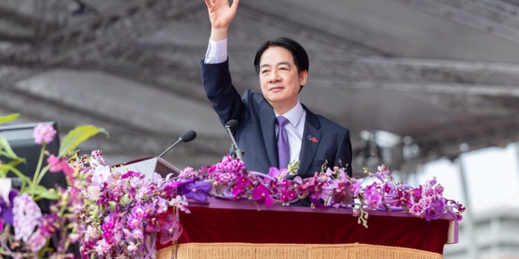 Taiwanese President Lai Ching-te waves from the podium at a National Day ceremony, as his government raises defense spending